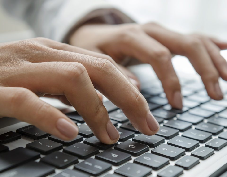 Closeup female hands typing on keyboard